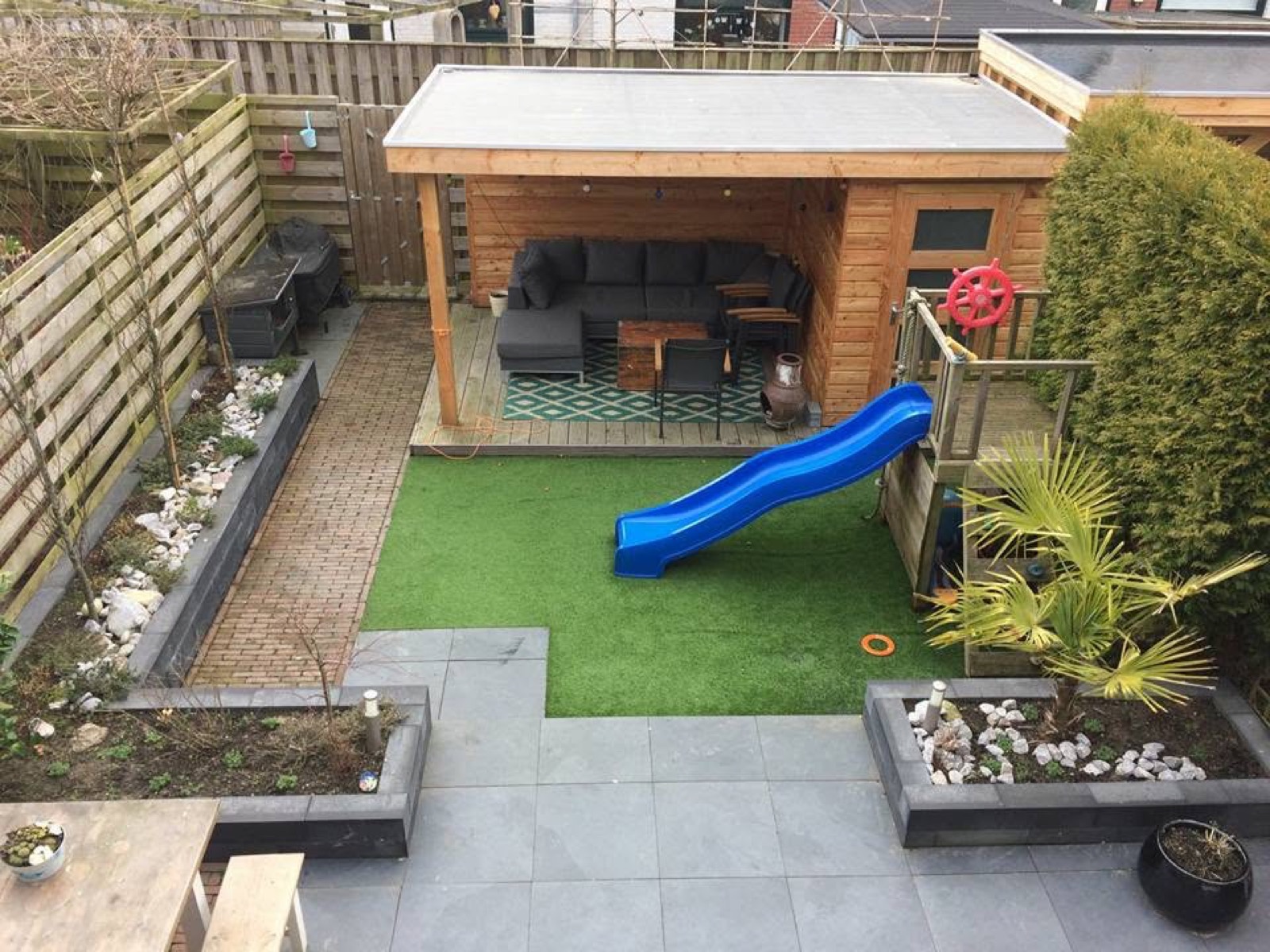 Gezinstuin met veranda, speelplek, bestrating en borders