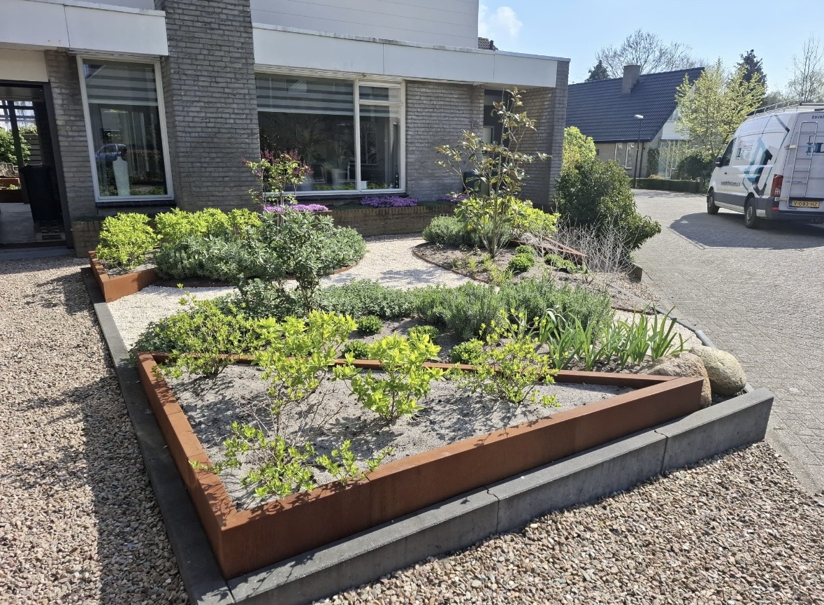 Voortuin met cortenstaal randen, grind, beplanting en rustige vakverdeling