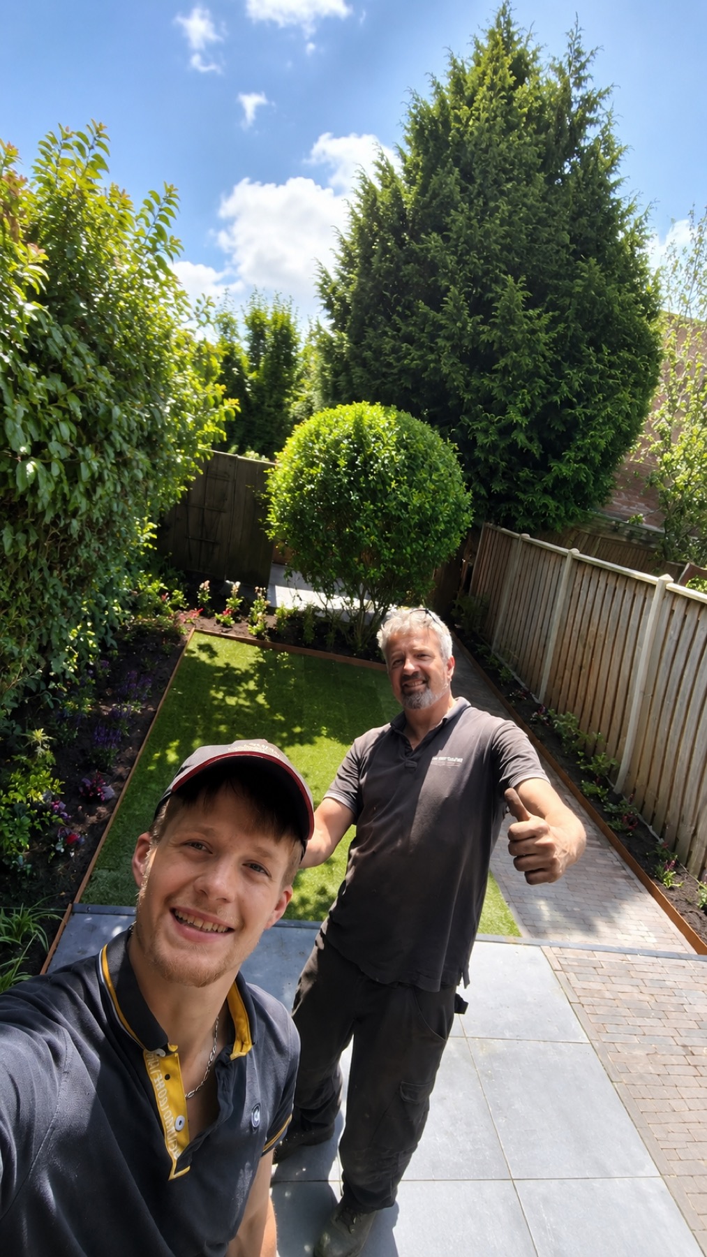 Jan Boer en Micha in een net opgeleverde tuin